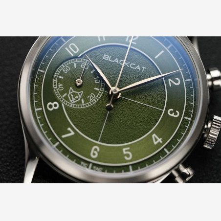 Verre saphir protégeant un cadran vert olive aux finitions satinées et sablées et sous-compteur des minutes avec logo Blackcat.