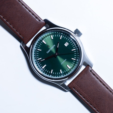 Cadran minimaliste soleillé vert, guichet date et index bâtons.