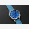 Montre bleu en acier, verre saphir et bracelet en tissu.